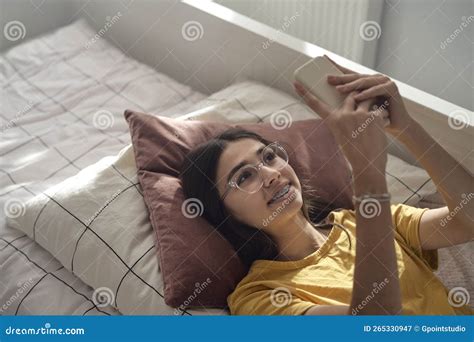 Adolescente Caucasiana Usando Telefone Celular E Deitado Na Cama Imagem De Stock Imagem De