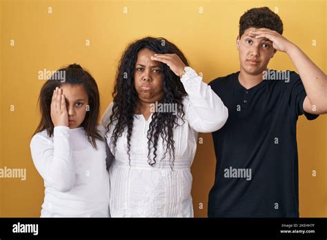 famille de mère fille et fils debout sur fond jaune inquiet et stressé au sujet d un problème