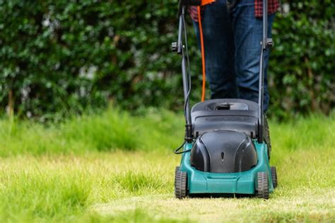 Premium Photo Worker Using A Lawn Mower Cutting Grass At Home