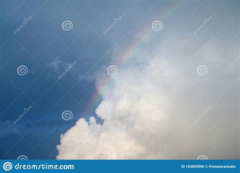 Colored Arc Of Rainbow On The Blue Sky With White Puffy