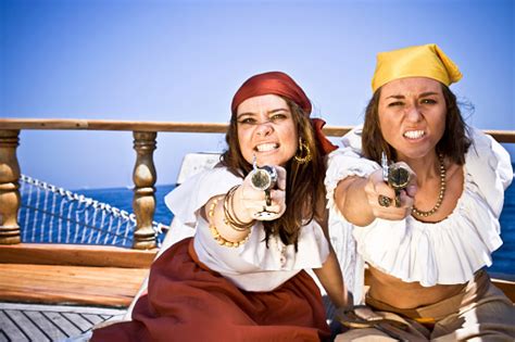 Aggressive Pirate Girls With Guns Aiming At Camera Stock Photo