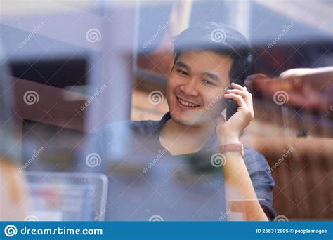 Taking A Call From A Loved One Smiling Asian Man Using A Mobile Phone