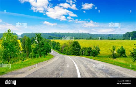Rural Paved Road Among Green Fields Stock Photo Alamy
