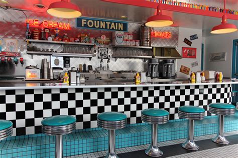 The Interior Of A Diner With Checkered Counter Tops And Stools In Front
