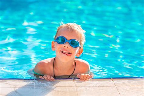 Cute Happy Little Boy In Goggles Swimming In The Swimming Pool Stock