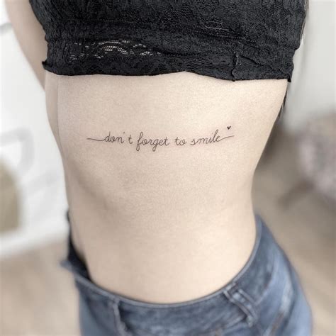 A Woman S Lower Back Tattoo Saying Don T Forget To Smile