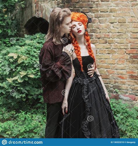 Gothic Couple Embracing In Halloween Costume Vampire In Victorian Clothes Redhead Woman In