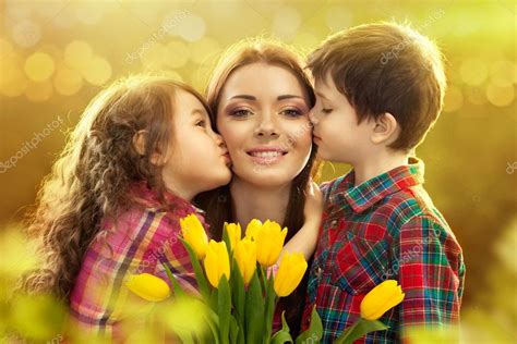 Happy Mother Kissed By Her Daughter And Son — Stock Photo © Svetaorlova