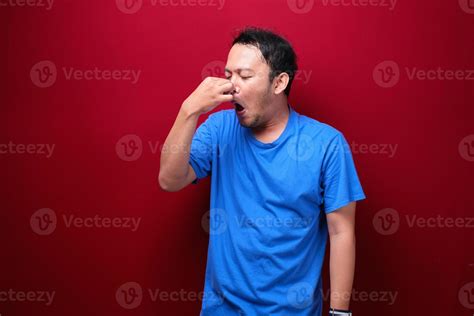 Young Asian Man Smelling Something Stinky And Disgusting 6437681 Stock
