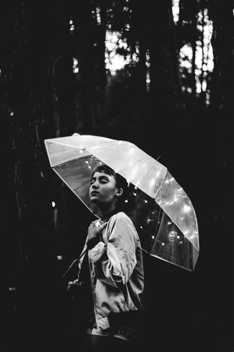 Grayscale Image Of Woman Walking Through The Rain While Holding