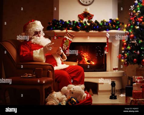 Happy Santa Claus Sitting At His Room At Home Near Christmas Tree And
