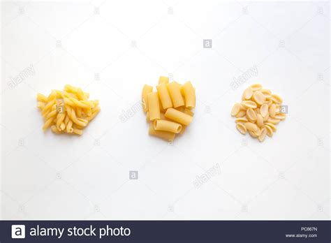 Three Heaps Of Raw Wheat Pasta With Various Shapes Isolated On White