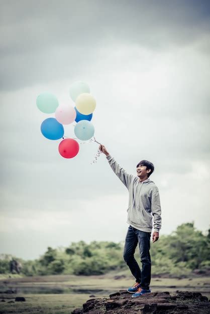 Free Photo Young Man Hand Holding Colorful Balloons