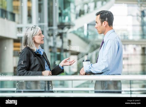 Serious Business People Talking In Lobby Stock Photo Alamy