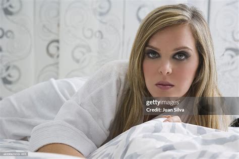 Woman Wearing Bathrobe Lying On Bed Portrait High Res Stock Photo