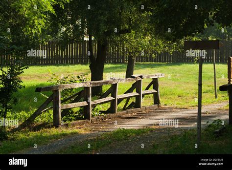 Old Wooden Bridge With Fence And Beautiful Grass Background Stock Photo
