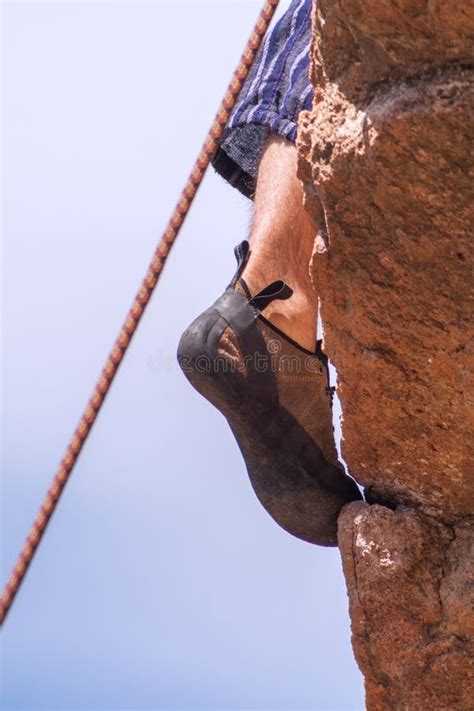 Rock Climbers Feet With Climbing Shoes On While Climbing Stock Photo