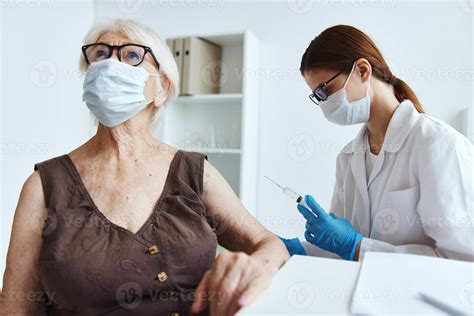 elderly woman patient sitting next to the nurse covid passport 22076617