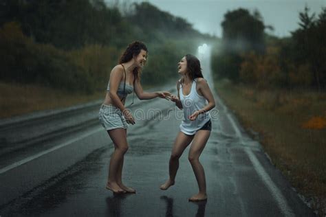 Meisjes Die Zich In De Regen Op Rijweg Bevinden Stock Afbeelding Image Of Verdienste Speels