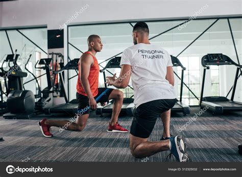Back View Personal Trainer Instructing African American Sportsman