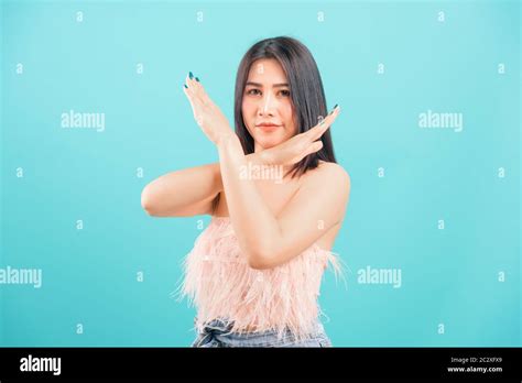 asian beautiful woman her showing say no hand sign looking to camera on blue background with