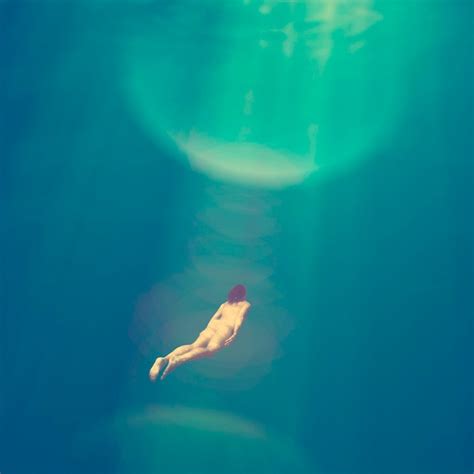 Фантастическая обнаженная женщина дайвер глубоко под водой Премиум Фото