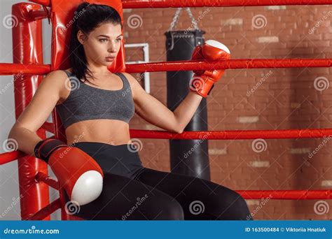 Boxing Woman Boxer In Gloves Sitting In The Corner Of Ring Leaning