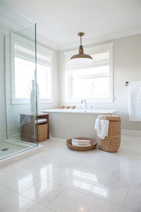 This bathroom has white tile on the floor and two thirds up the wall, in addition to a gleaming white sink, bathtub, bidet, and regular toilet commode. 18 large white bathroom floor tiles ideas and pictures 2020