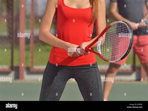 Couple Playing Doubles At The Tennis Court Woman Body At First Plane