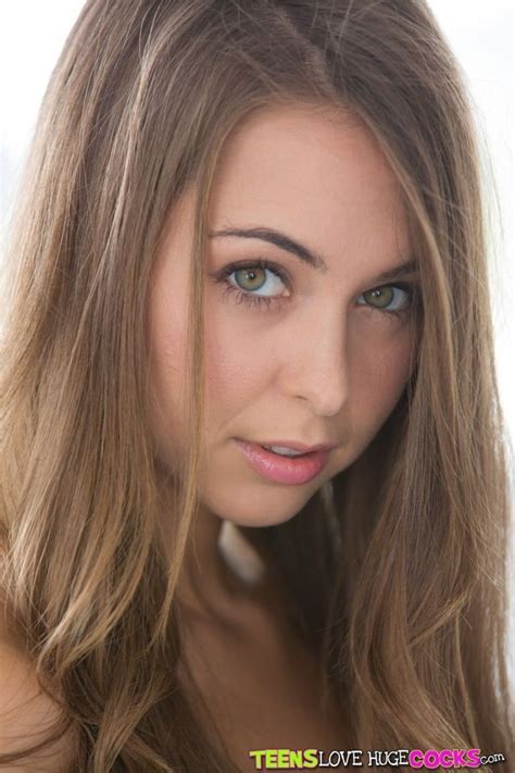 A Woman With Long Hair And Blue Eyes Posing For A Photo In Front Of The Camera