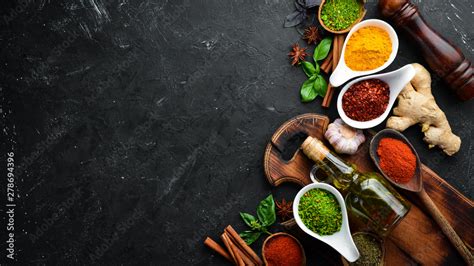Colorful Herbs And Spices For Cooking Indian Spices On A Black Stone