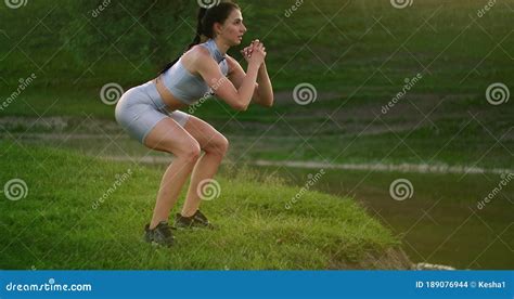 Squats And Jumps Up A Woman Does Exercises For The Muscles Of Her Thighs And Legs On The Grass