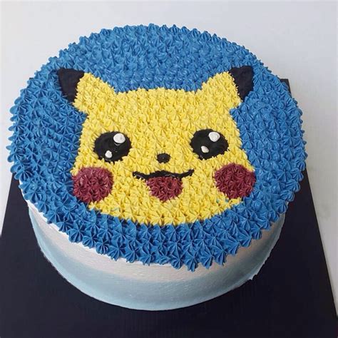 A Blue And Yellow Cake With A Pikachu Face On It