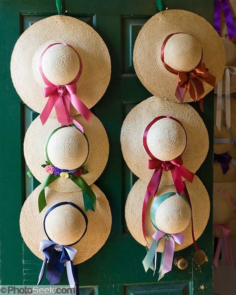 Straw Hats With Red Maroon Pink Green And Blue Ribbons Hang On The