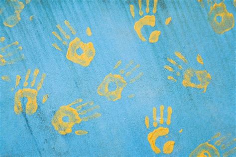 Premium Photo Handprints On The Wall Yellow Prints On A Blue Wall The Background Of The