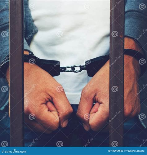 Handcuffed Hands Of A Businessman Behind The Bars Of A Prison C Stock