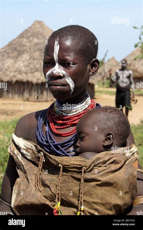 Portrait Of A Young Karo Tribe Mother Holding Her Sleeping Baby Close