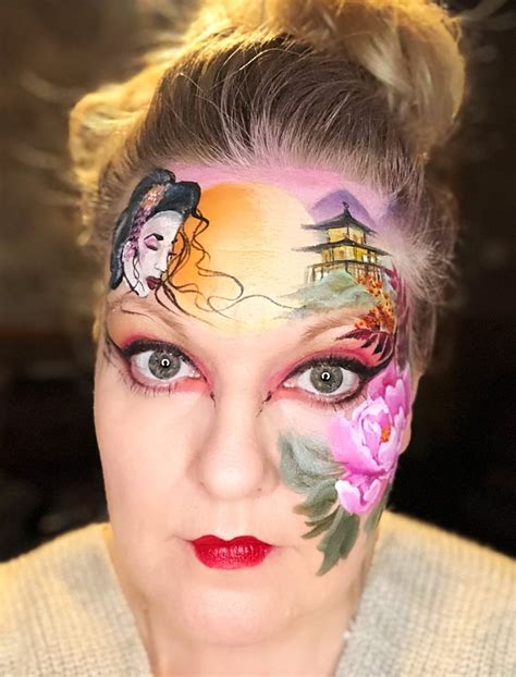 A Woman With Her Face Painted Like A Geisha Doll And Flowers On Her Forehead