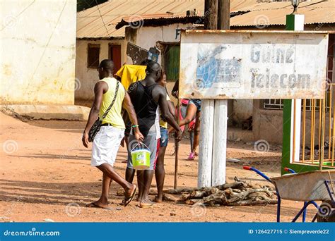 unidentified local man carries a bucket in a village in guinea editorial image image of