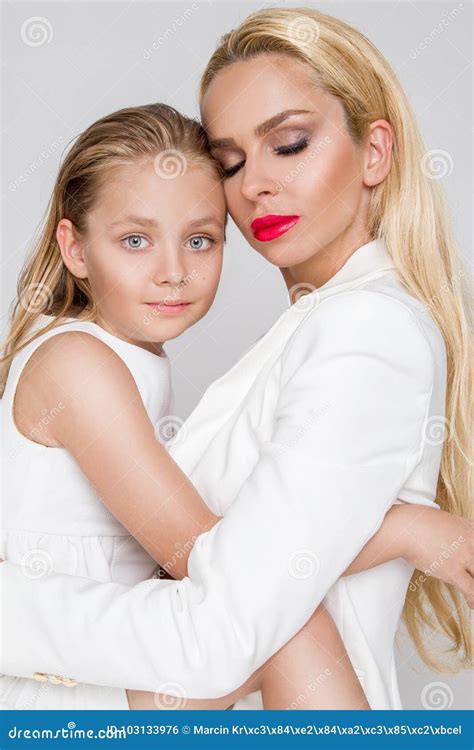 Beautiful Woman Mother With Daughter Snuggling Together And Show Love Smartly Dressed In A