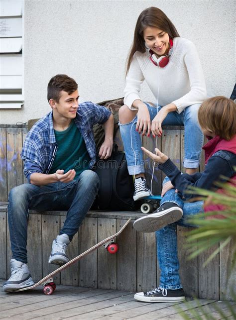 Teenagers Hanging Out Outdoors And Discussing Something Stock Image