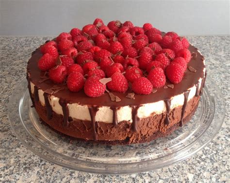 A Chocolate Cake Topped With Raspberries On Top Of A Counter