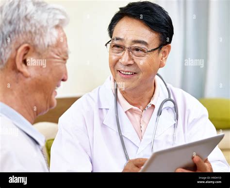 Asian Doctor Hablando Con Un Paciente Senior Feliz Y Sonriente Fotografía De Stock Alamy