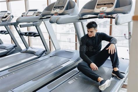Stylish Guy In The Gym Sits Resting On The Treadmill Healthy Lifestyle
