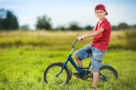 Premium Photo Young Boy Riding A Bicycle On A Field