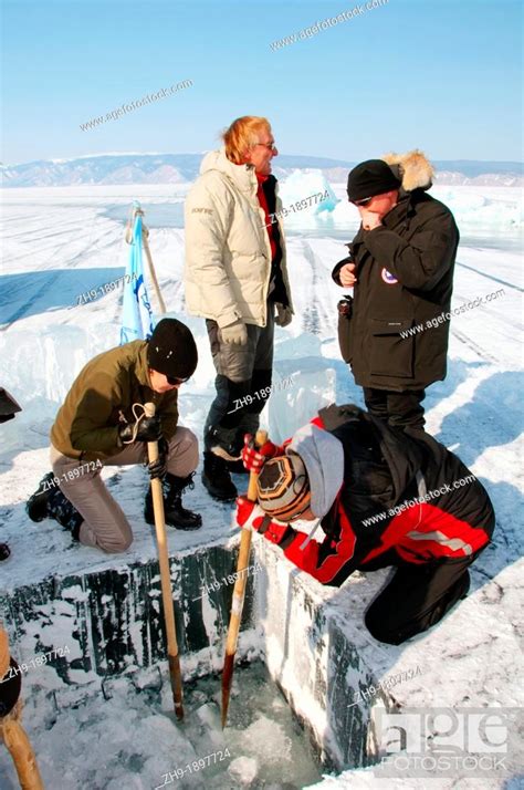 Man Sawing An Ice Hole For Ice Diving In Lake Baikal Olkhon Island Siberia Russia Eurasia