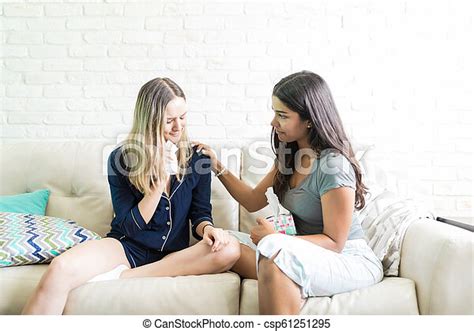 Woman Comforting Crying Friend On Sofa At Home Young Caring Woman