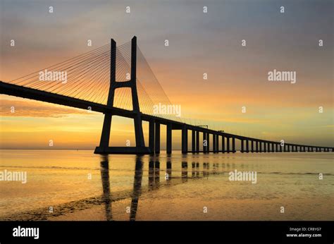 Vasco Da Gama Bridge In Lisbon Portugal During Sunrise With Reflection