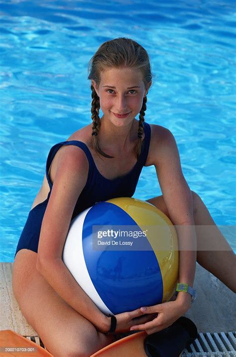 Teenage Girl Sitting Besides Poolside With Beach Ball Foto De Stock