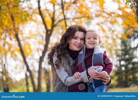 Mother With Her Son Walks In The Autumn Park Stock Photo Image Of